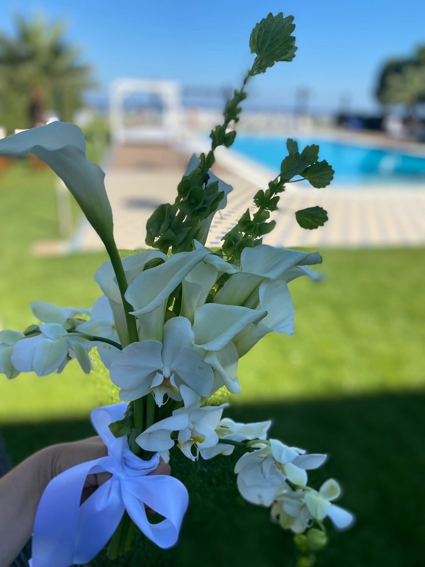Ανθοδέσμη με λευκές calla και ορχιδέες δίπλα σε πισίνα